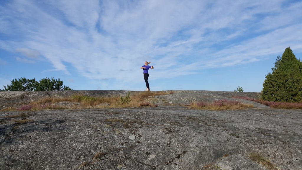 Tjej som joggar bland klipporna