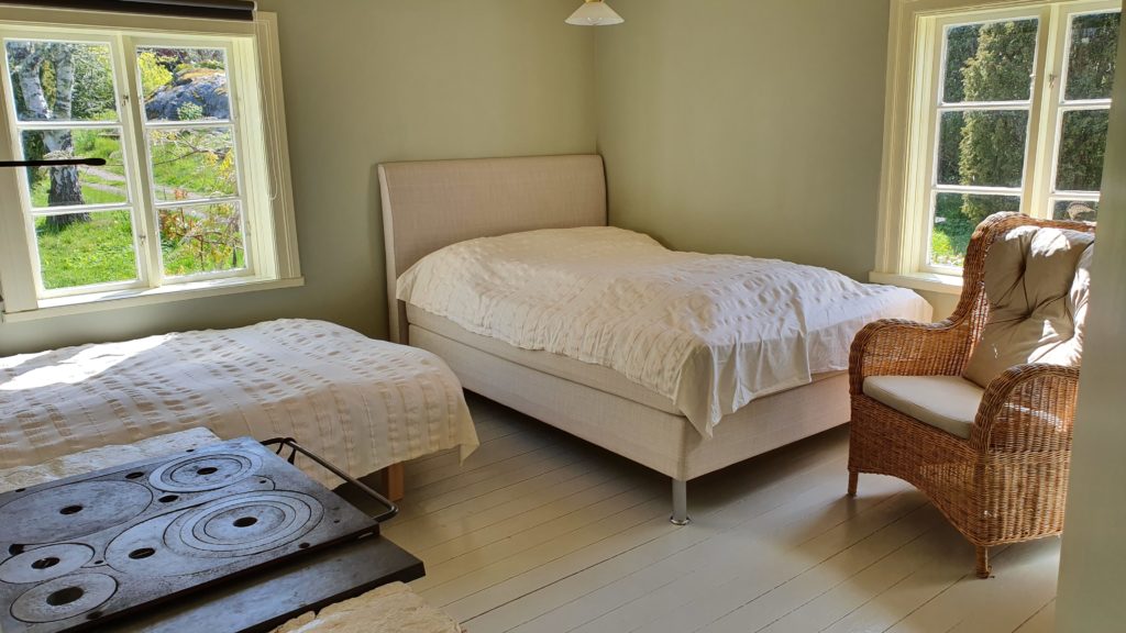 Photo showing room 1 with two beds and a wood stove.